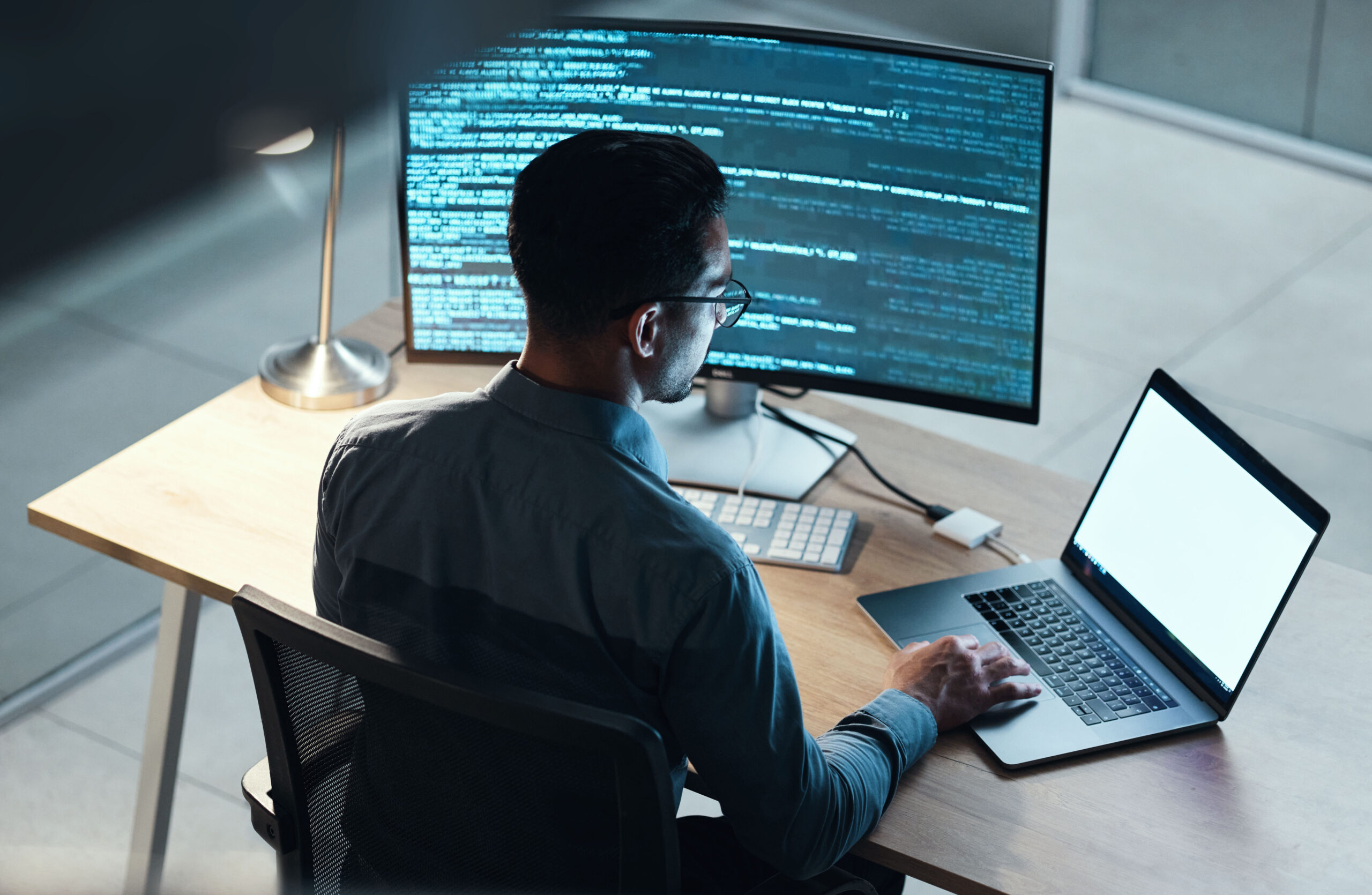 Man, programmer and coding at night on laptop mockup screen for networking, malware or software at the office. Male person, coder or developer working late in computer display in problem solving
